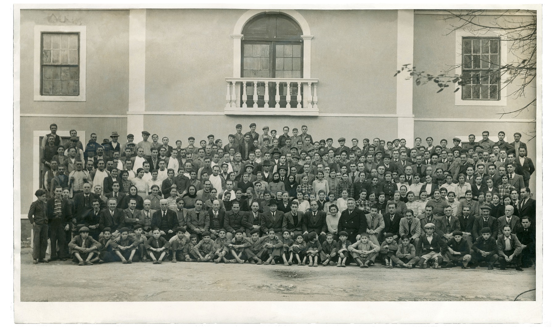 Foto de conjunto dos operários da Nacional Fabrica de Vidros, na Marinha Grande, que Tereza Arriaga desenhou. Em abaixo, sentados no chão, são visíveis os meninos aprendizes de vidreiro