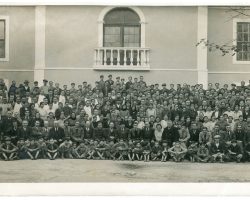 Foto de conjunto dos operários da Nacional Fabrica de Vidros, na Marinha Grande, que Tereza Arriaga desenhou. Em abaixo, sentados no chão, são visíveis os meninos aprendizes de vidreiro